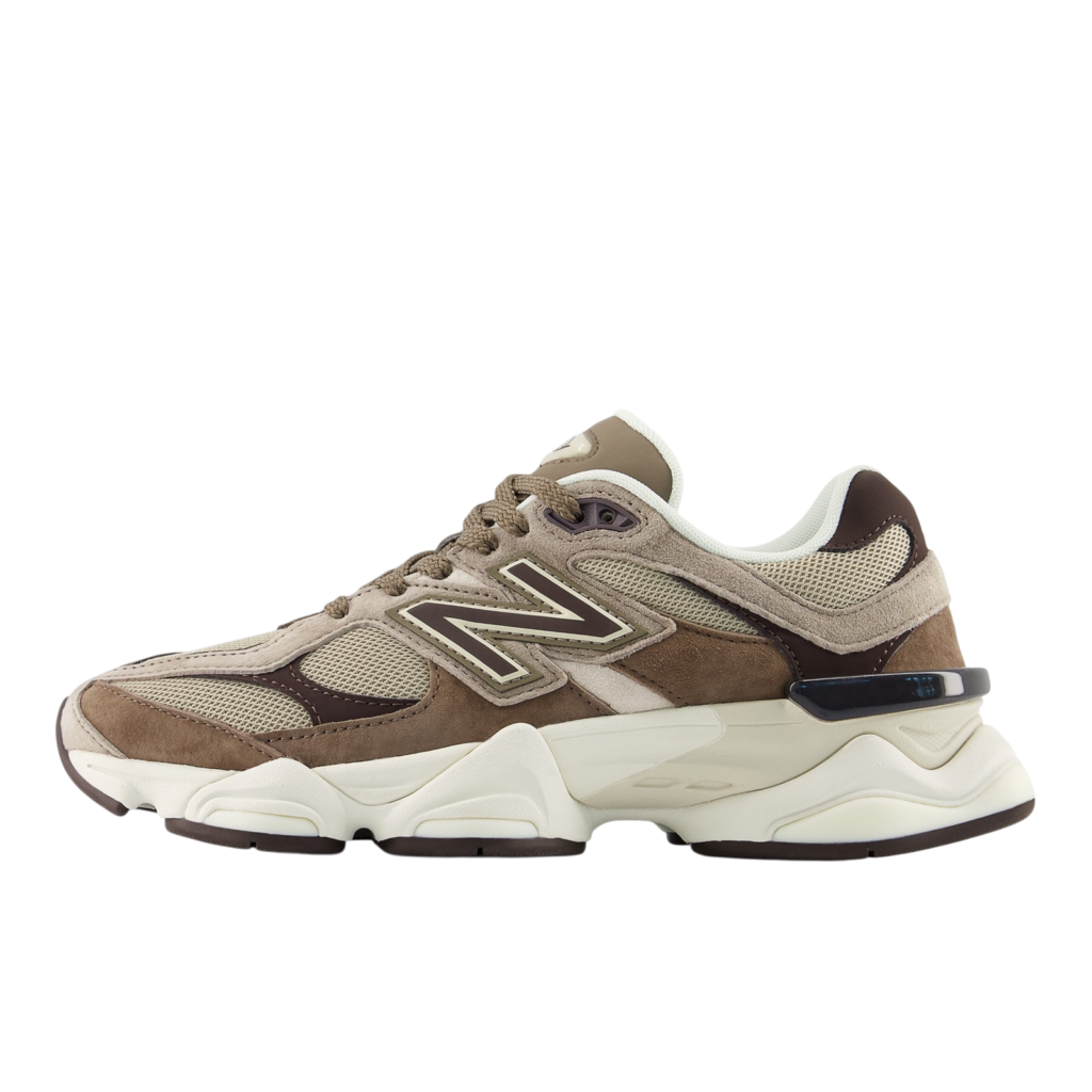 Partial view of a beige-brown New Balance sneaker with white sole, showing mesh and suede panels.