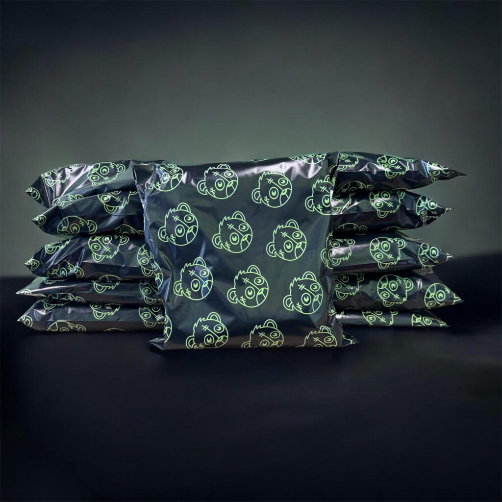 Glossy black stacked wrappers printed with neon-green smiley faces on a dark background, creating a bold, playful pattern.